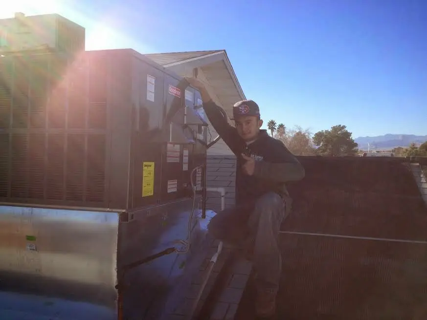 HVAC technician performing Air Duct Cleaning on a rooftop unit in Lewisville